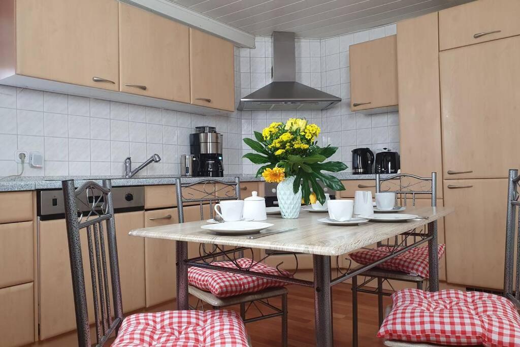 Stadtb,BurgGleiberg,Whirlpool,2xBad,3ZimmerNetflix في Gleiberg: مطبخ مع طاولة عليها إناء من الزهور