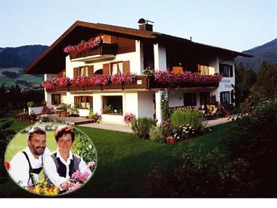 a picture of a couple in front of a house at Gästehaus Schmuck in Reit im Winkl