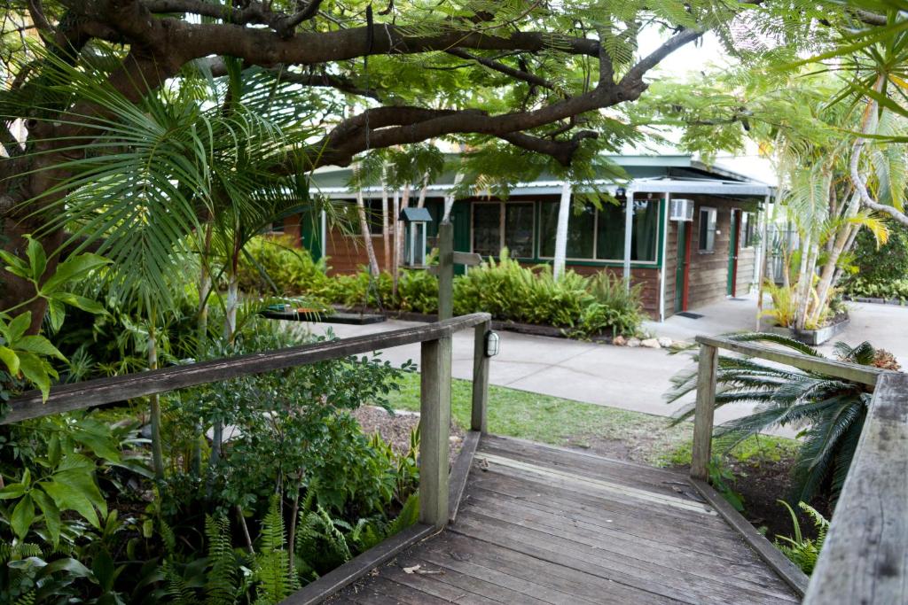 a walkway leading to a garden area with trees at Woolshed Eco Lodge in Hervey Bay