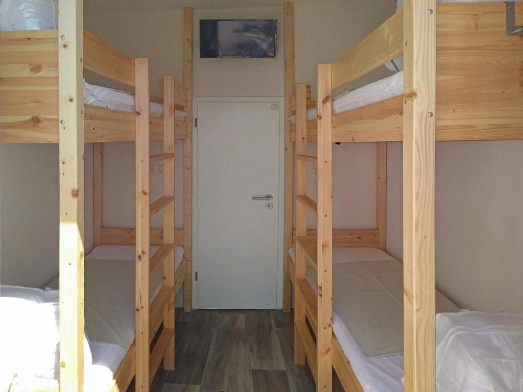 a room with three bunk beds and a door at Mola Land-Kajüten in Breege