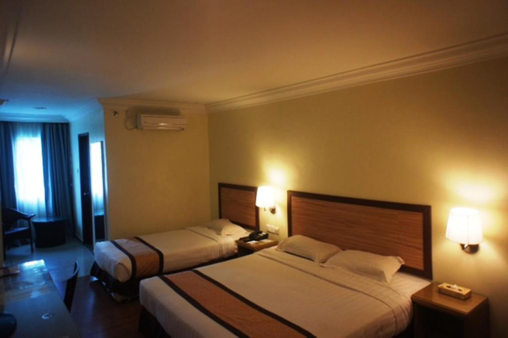 Postel nebo postele na pokoji v ubytování Tyng Garden Hotel