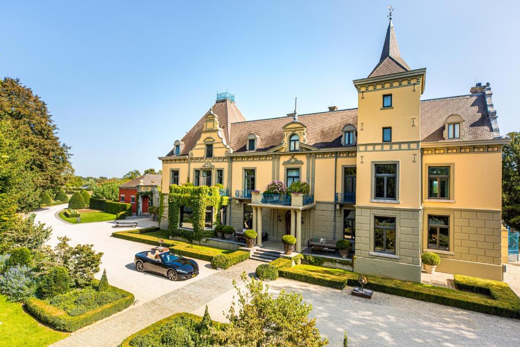 uma casa com um carro estacionado em frente em Landgoed Kasteel de Hoogenweerth em Maastricht