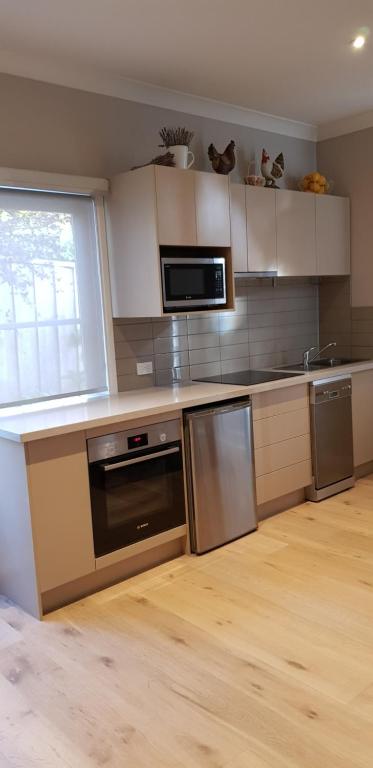een keuken met roestvrijstalen apparatuur en een raam bij Oxford Rise Apartment in Bayswater