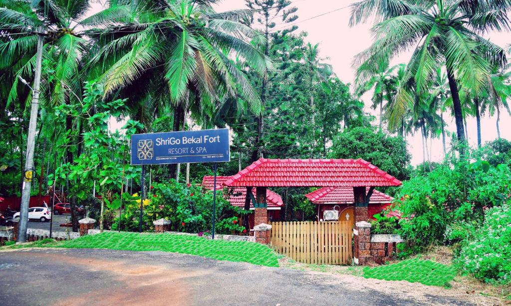 a street sign in front of a building with palm trees at ShriGo Bekal Fort Resort & Spa in Bekal