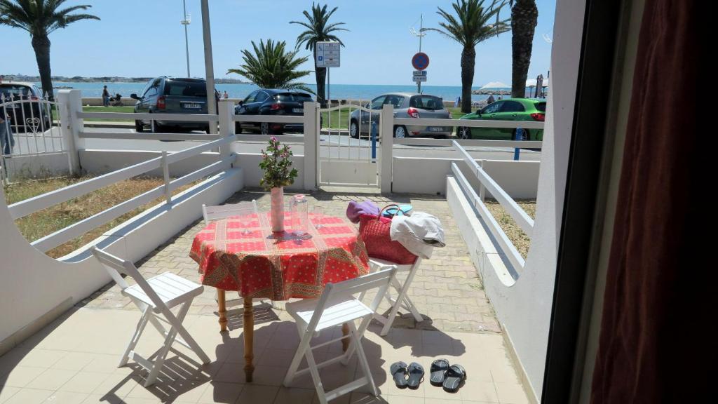 une table et des chaises sur le balcon d'une maison dans l'établissement Sol-y-Days Goeland, Appartement avec terrasse front de mer et place de parking en centre-ville, au Grau-du-Roi