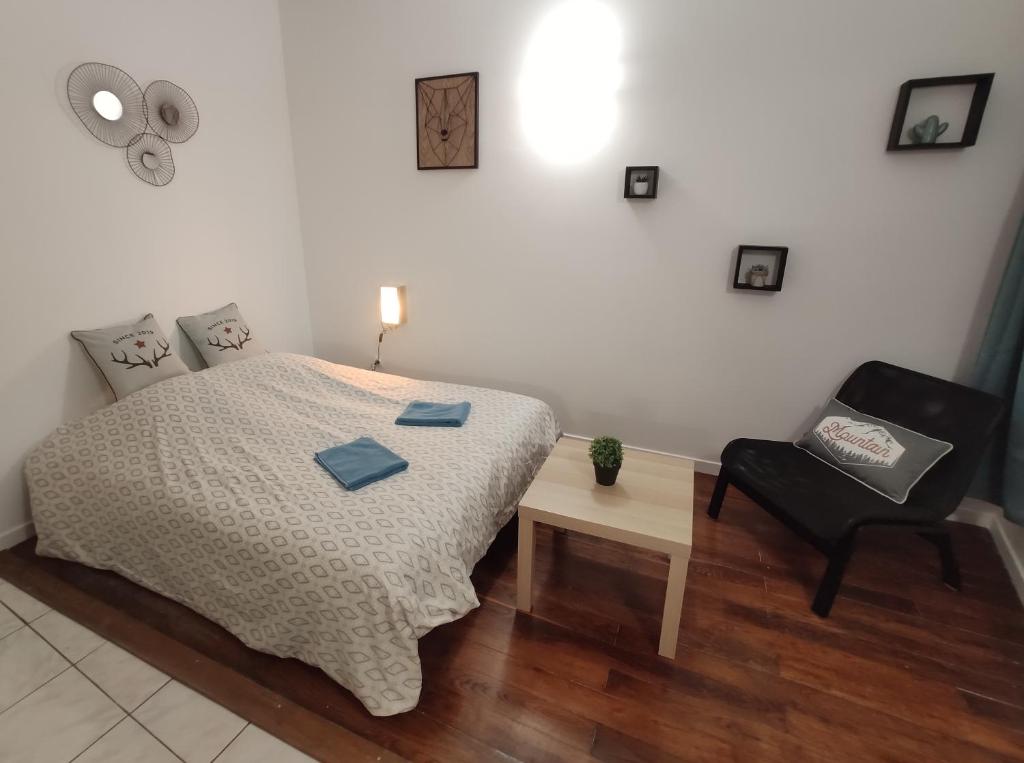 1 dormitorio con 1 cama y 1 silla negra en Mâcon Centre ville-gare-wifi-cosy-parking public à proximité en Mâcon