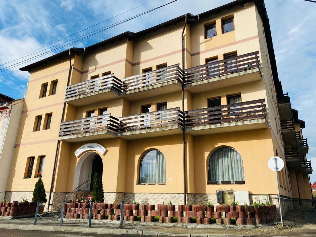 un edificio con balcones en un lateral en Pensiune Restaurant Indus, en Ocna Sibiului