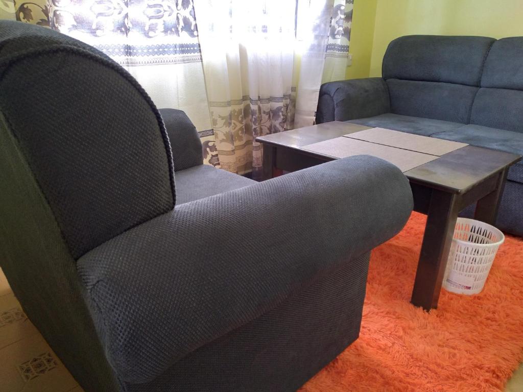 a living room with a chair and a table at Crown Hotel Kericho in Kericho