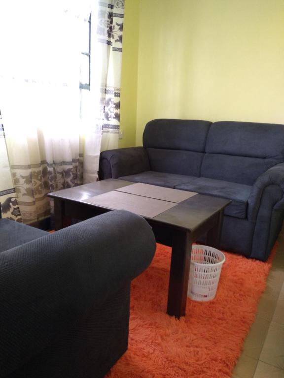 a living room with a couch and a coffee table at Crown Hotel Kericho in Kericho