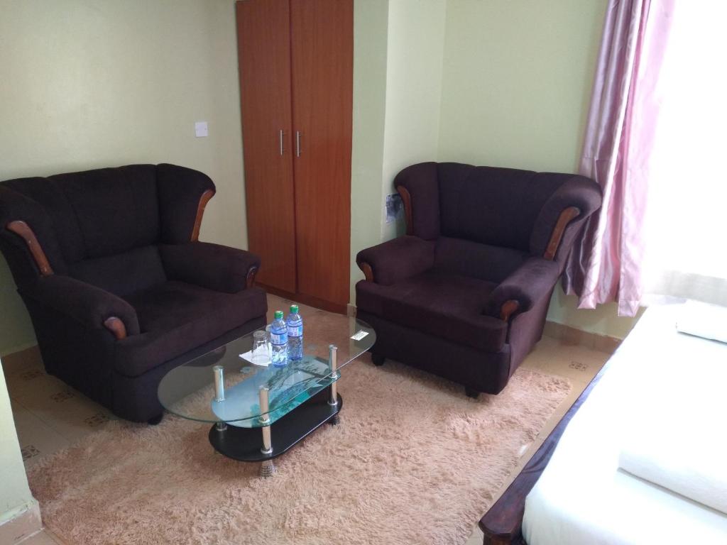 2 sillas y mesa de centro en la sala de estar en Crown Hotel Kericho, en Kericho