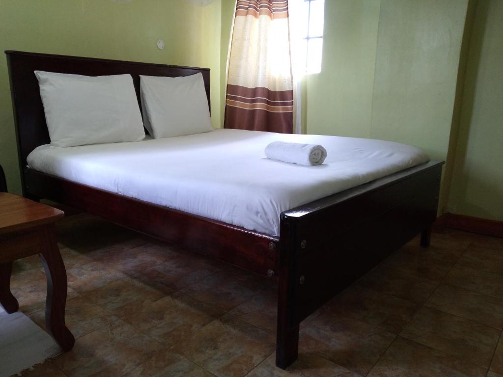 a bed in a room with a large white mattress at Crown Hotel Kericho in Kericho