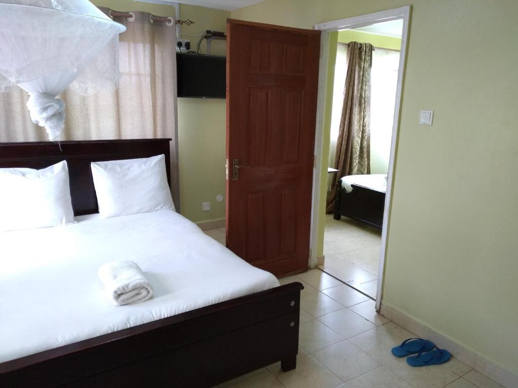 a bedroom with a bed with a white towel on it at Crown Hotel Kericho in Kericho