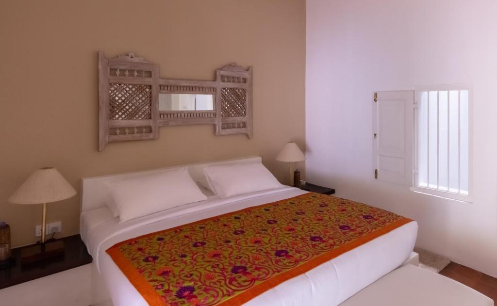 a bedroom with a bed with a colorful blanket at Nyne Hotels Rock Villa, Bentota in Bentota