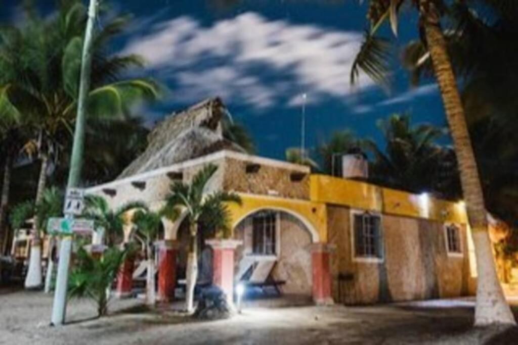 una casa con palmeras delante en Private Beachhouse Hacienda Antigua, en El Cuyo