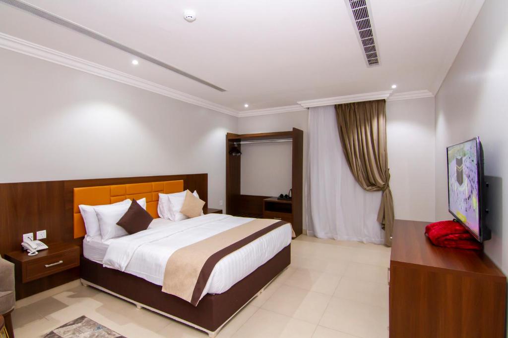 a bedroom with a bed and a television in it at ال متعب سويتس الفلاح 3 in Riyadh