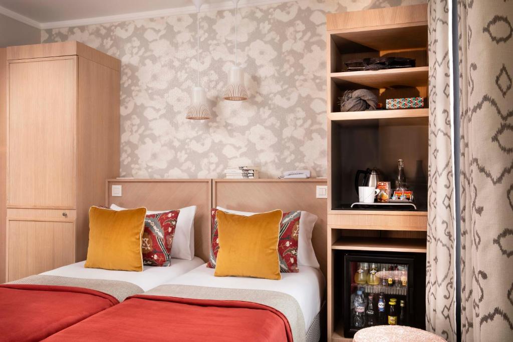 1 dormitorio con 2 camas con almohadas amarillas y rojas en Jardins Eiffel, en París
