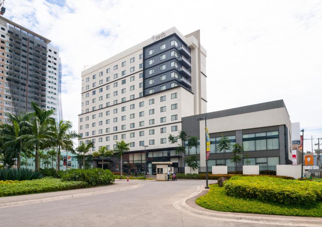 un edificio de oficinas en una ciudad con palmeras en Seda Abreeza Hotel, en Davao City