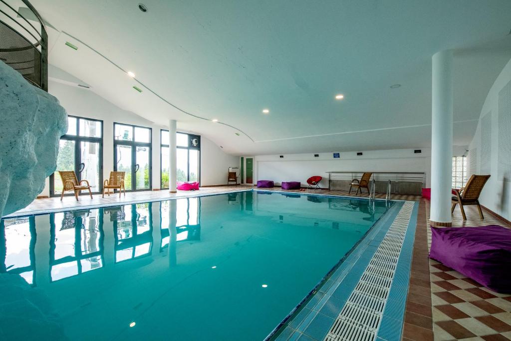 a large swimming pool with blue water in a house at Hotel Sunce Vlašić in Vlasic