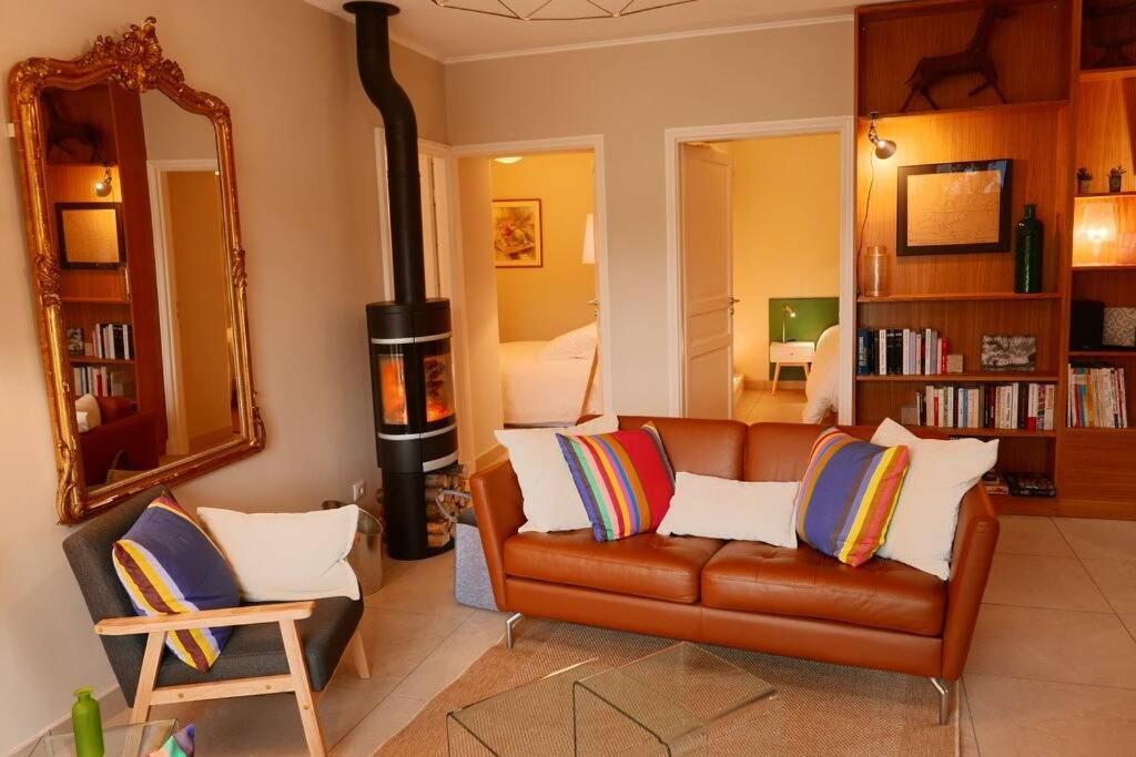 a living room with a couch and a wood stove at Le Hameau du Buron - "Le Petit Buron" - Option SPA in Eyzin-Pinet