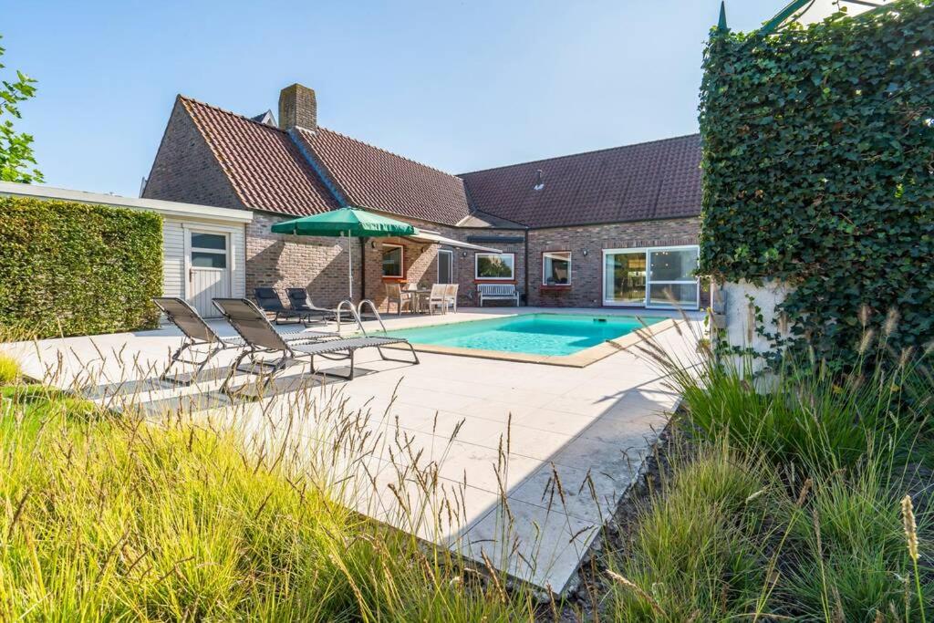 um quintal com uma piscina e uma casa em Villa with heated swimming pool, sauna and garden em Damme