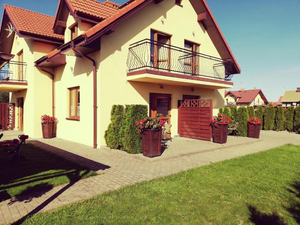 Casa con 2 balcones y 2 macetas de flores en Villa Zoja, en Rowy