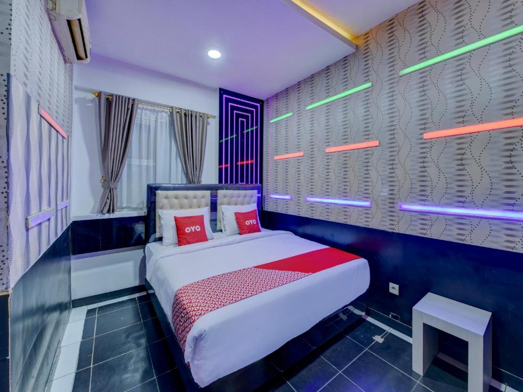 a bedroom with a bed with red pillows at Super OYO 4010 Zaara Guest House Syariah in Padang