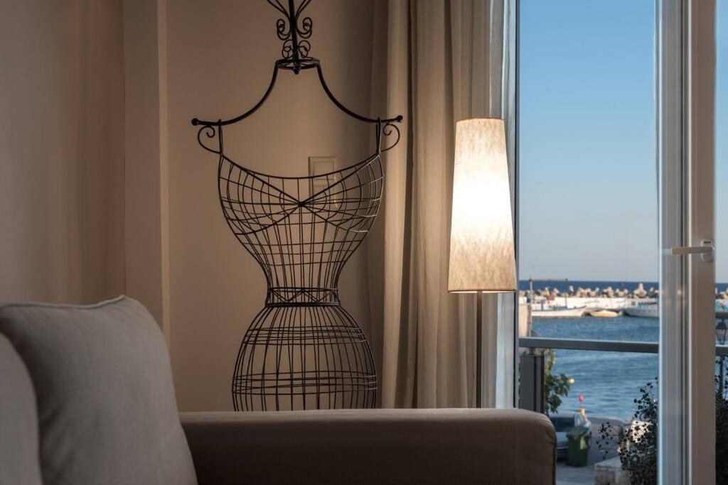 イエラペトラにあるIoanna Bayview Luxury Apartmentの窓際のリビングルームに座る金属の花瓶