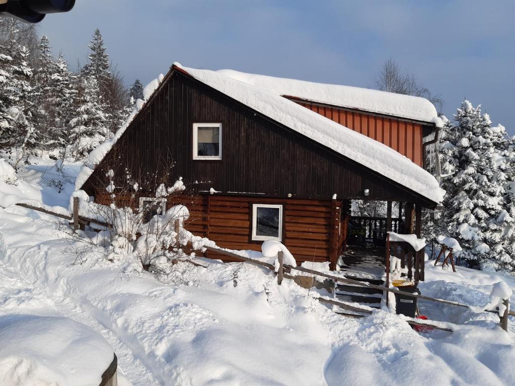 ein Blockhaus mit Schnee seitlich in der Unterkunft Villa Victoria in Kamesznica