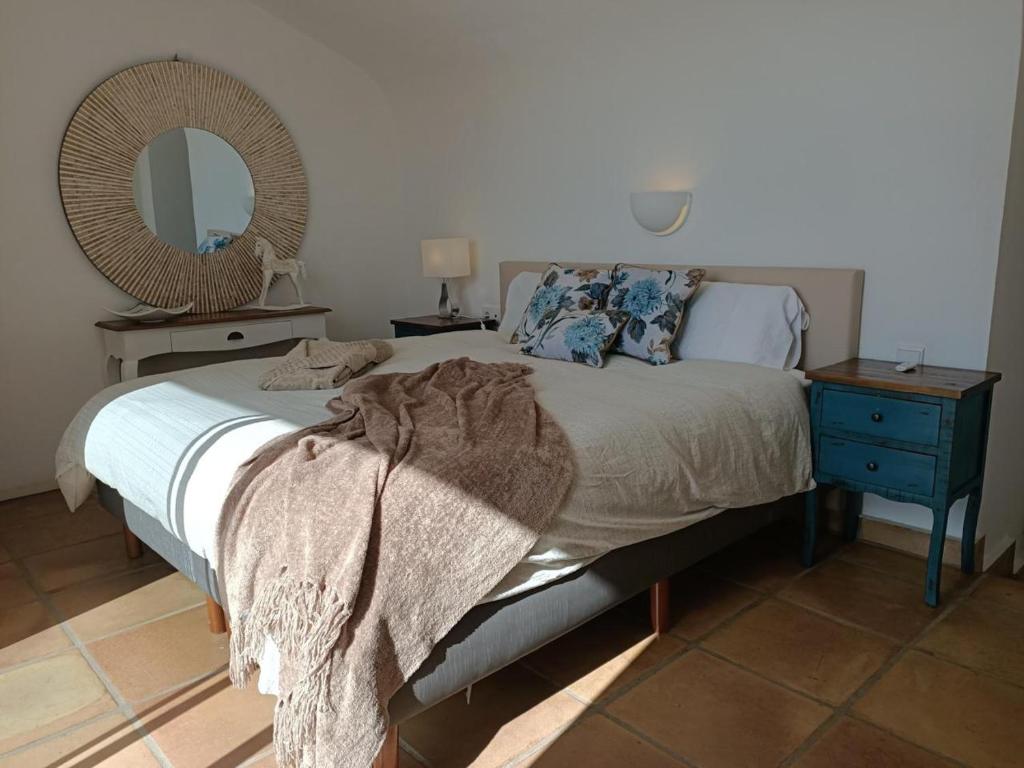 1 dormitorio con 1 cama con mesita de noche y espejo en Villa AMALIA, en Costa Calma