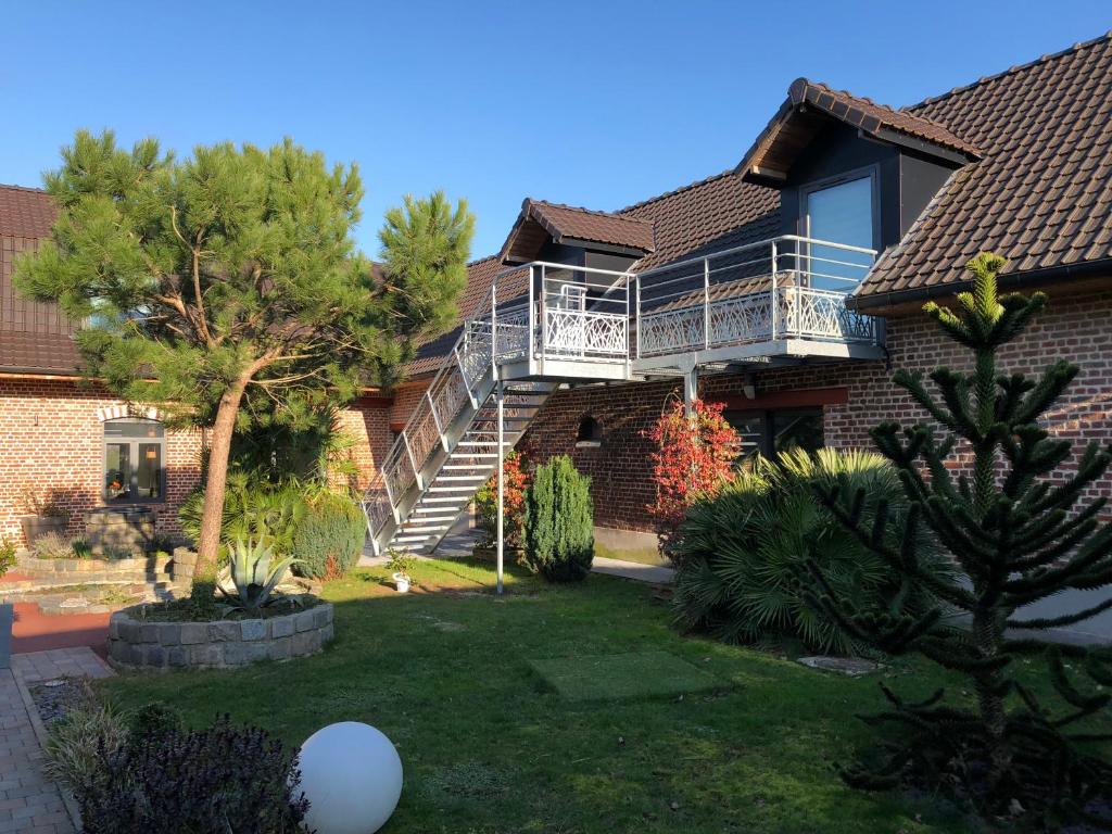 une maison avec un balcon et une cour dans l'établissement Aux Herbes Hautes, à Fleurbaix