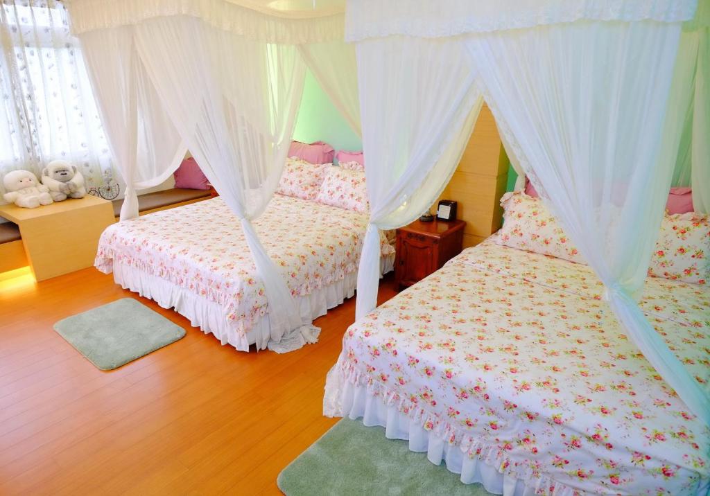 1 dormitorio con 2 camas, cortinas y alfombra en Spring Garden Homestay en Hualien