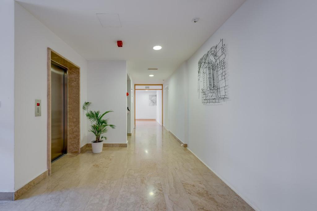 a hallway with white walls and a drawing on the wall at Hotel Pax in Split