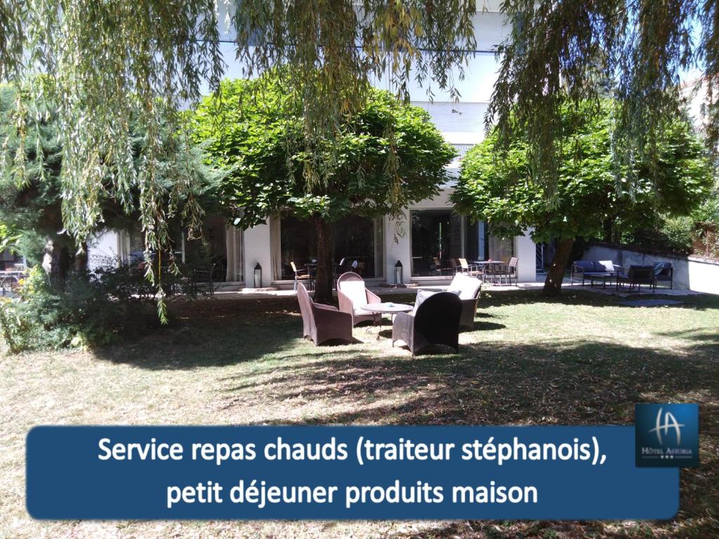 a building with chairs and trees in a yard at Hotel Astoria in Saint-Étienne