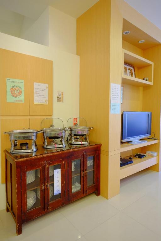 a room with a tv and a counter with dishes at Spring Garden Homestay in Hualien City