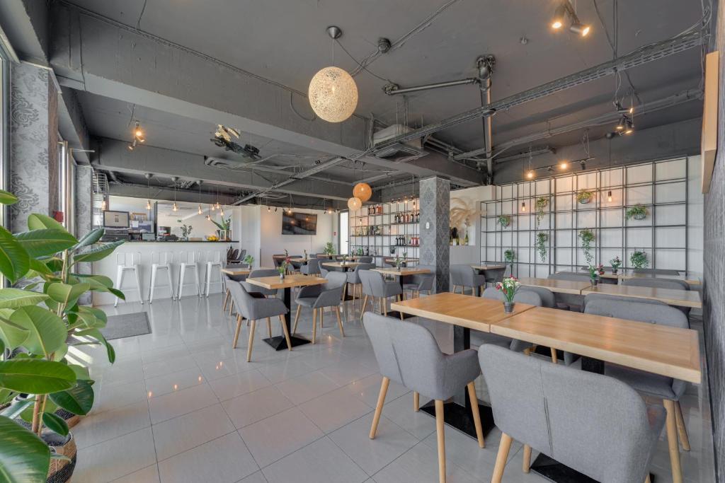 a restaurant with wooden tables and chairs and plants at Hotel Pax in Split