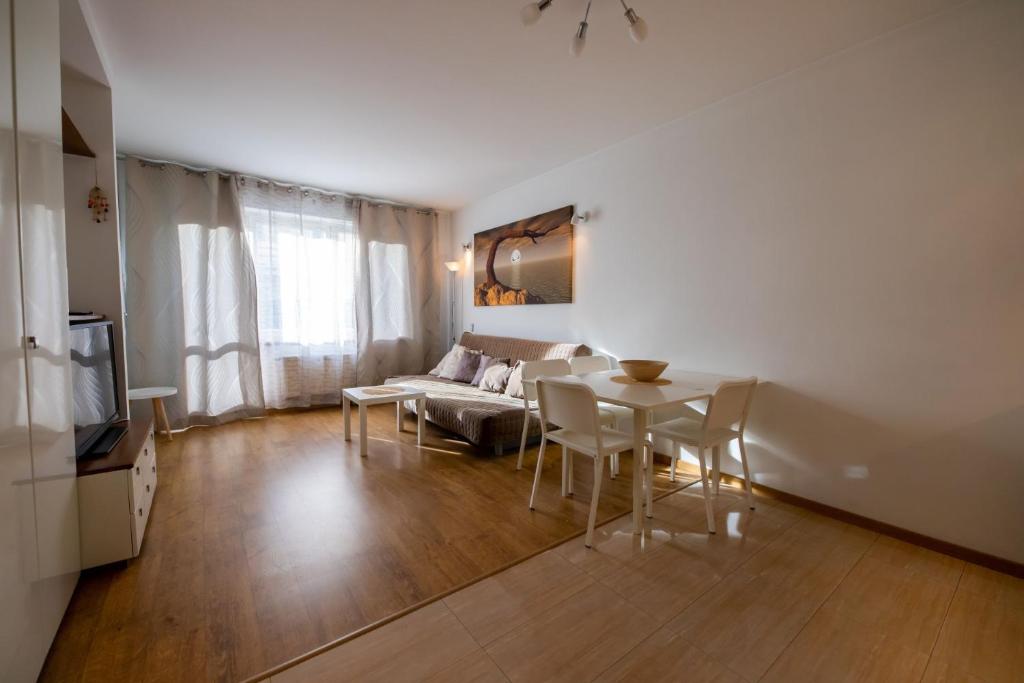 - un salon avec une table et un canapé dans l'établissement Victus Apartamenty, Apartament Liczi, à Sopot