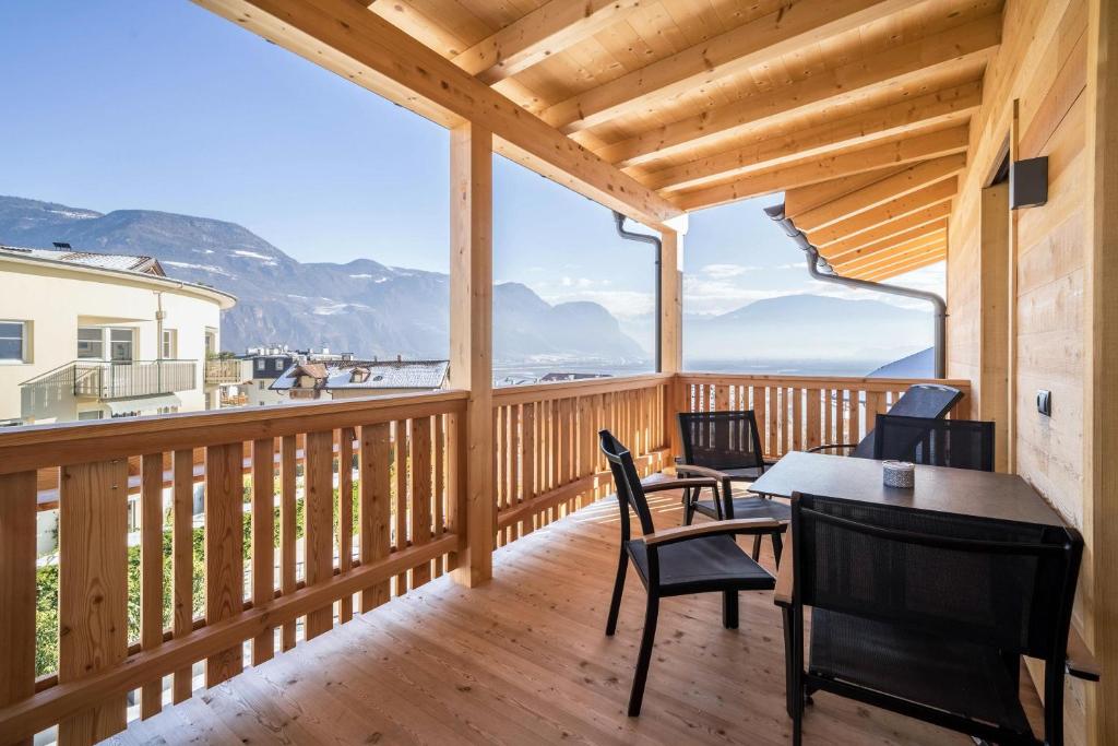 una terrazza in legno con sedie e un tavolo sopra di Apt Lärche - Nockerhof ad Andriano