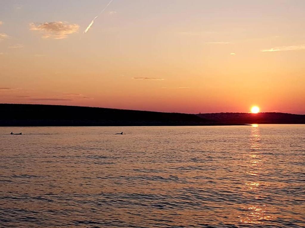 a sunset over a large body of water at Holiday Home Aurora in Ližnjan