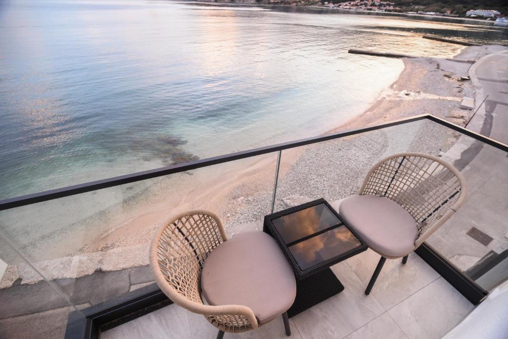 two chairs and a table on a balcony overlooking the water at Villa San Antonio 3-PALADA in Baška