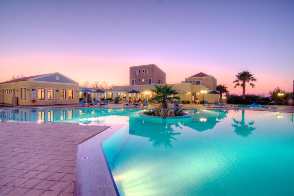 a large swimming pool in a resort at dusk at Sweety Club Solimar Emerald ALL INCLUSIVE in Adelianos Kampos