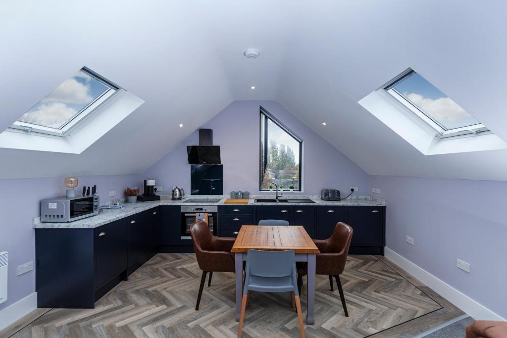 a kitchen with a table and chairs and skylights at Luxury Loft Apartment by Bootique Wakefield in Wakefield