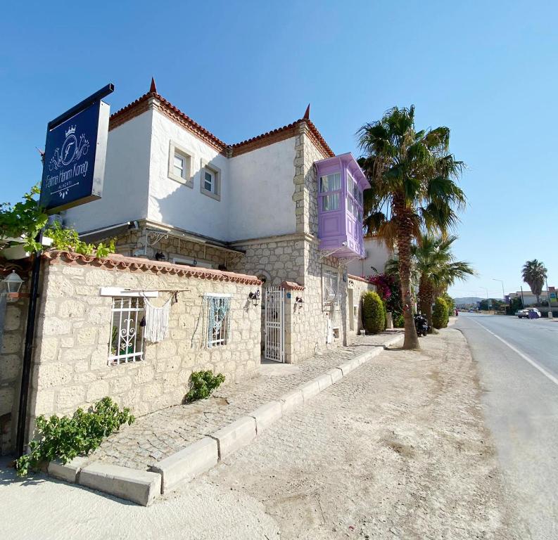 a building on the side of a road with a palm tree at Fatma Hanım Konağı Alaçatı in Izmir