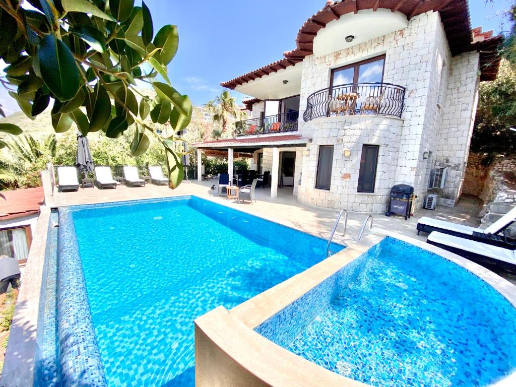 a swimming pool in front of a house at Club Hotel Barbarossa in Kas