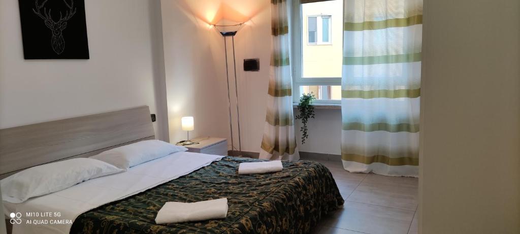 ein Schlafzimmer mit einem Bett, einer Lampe und einem Fenster in der Unterkunft Sweet Napoli in Neapel