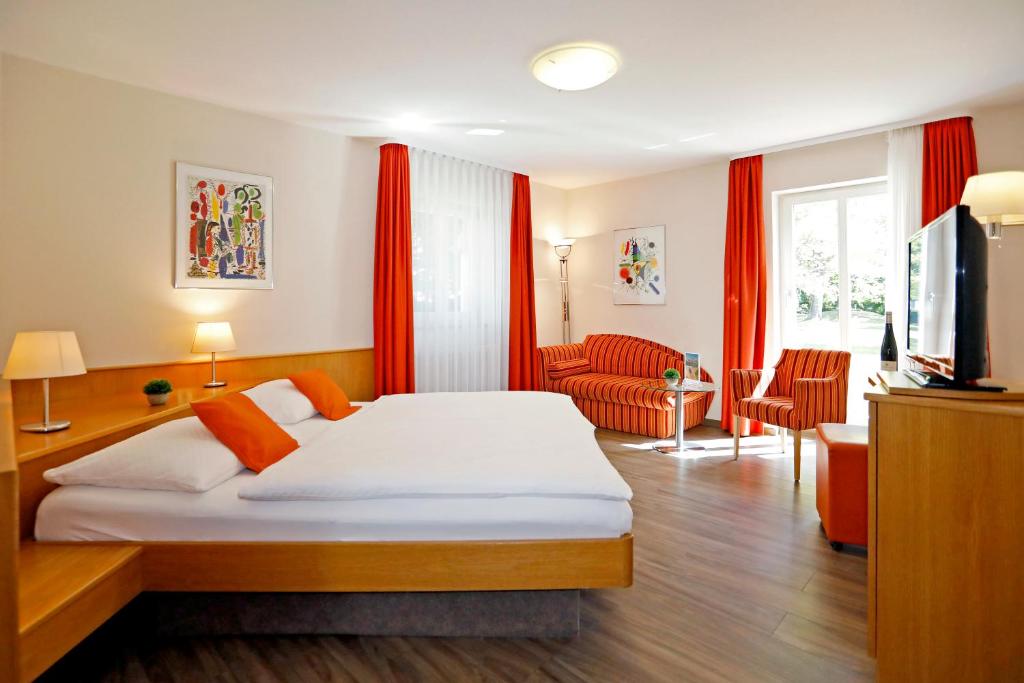 a hotel room with a bed and a television at Landhotel Altes Wasserwerk GbR in Freinsheim