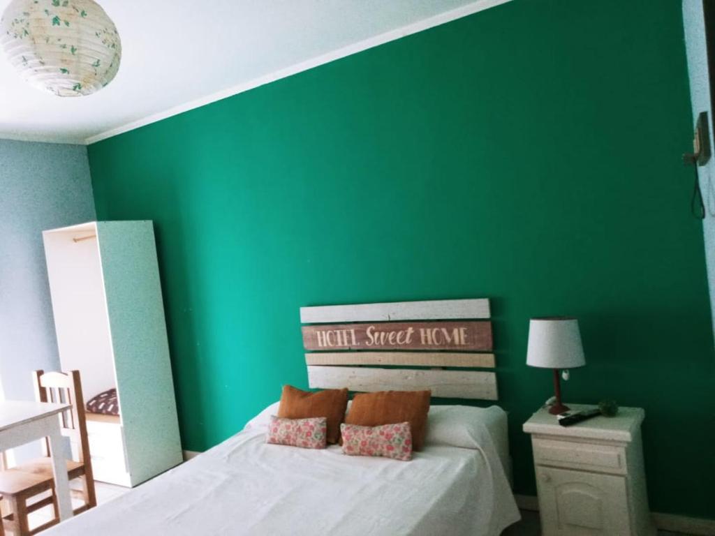 a green bedroom with a bed and a green wall at Hotel Are Pora in Gualeguaychú