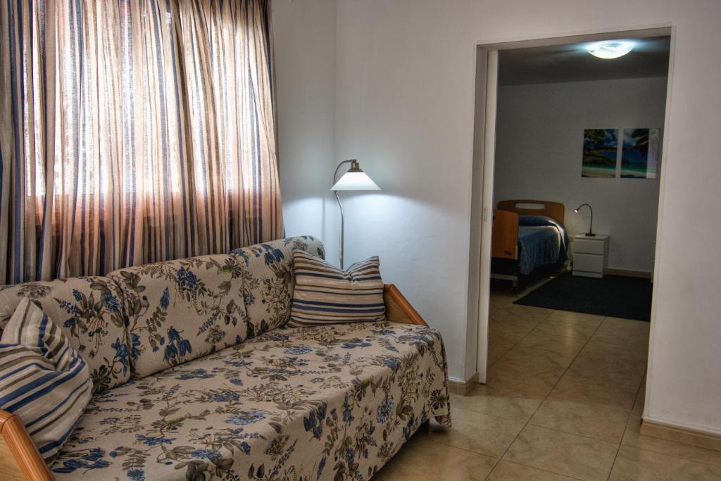 sala de estar con sofá y dormitorio en La Casita, a dos pasos de la playa, en Los Cristianos
