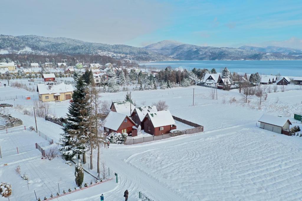 una ciudad cubierta de nieve con casas y un lago en Ośrodek Wypoczynkowy IGOR nad Jeziorem Żywieckim, en Żywiec