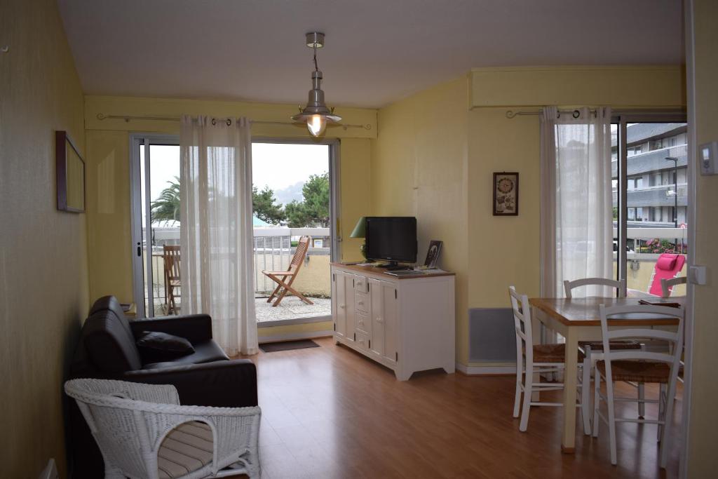 un salon avec une table et une salle à manger dans l'établissement Appartement rénové situé plage de Trestraou à PERROS-GUIREC - Réf 857, à Perros-Guirec