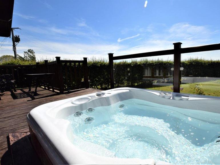 a jacuzzi tub sitting on top of a deck at Pheasant Lodge Scottish Borders in Carlisle